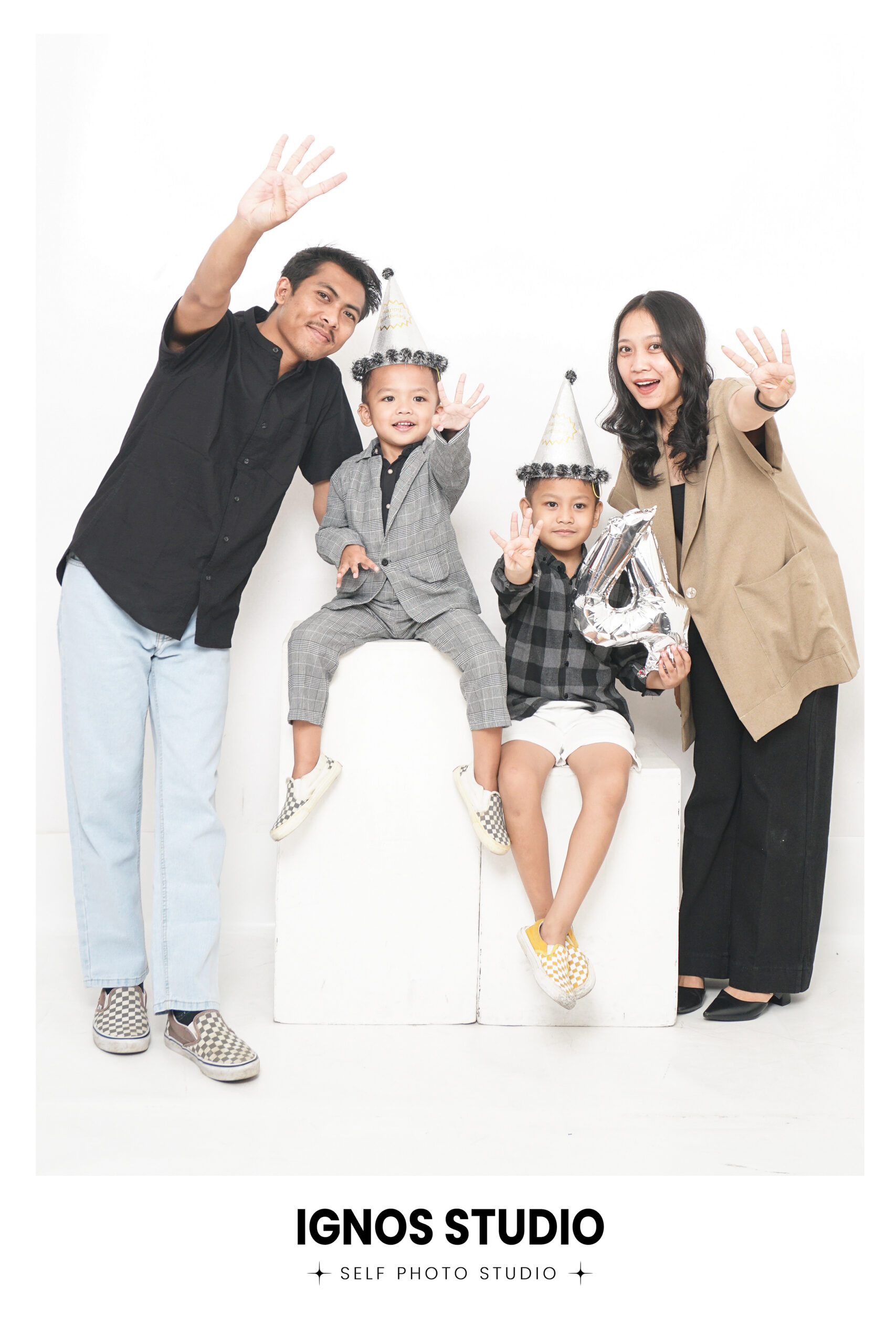 Sesi self photo keluarga di Ignos Studio Bali, merayakan ulang tahun anak yang ke-4 dengan properti balon dan topi pesta.