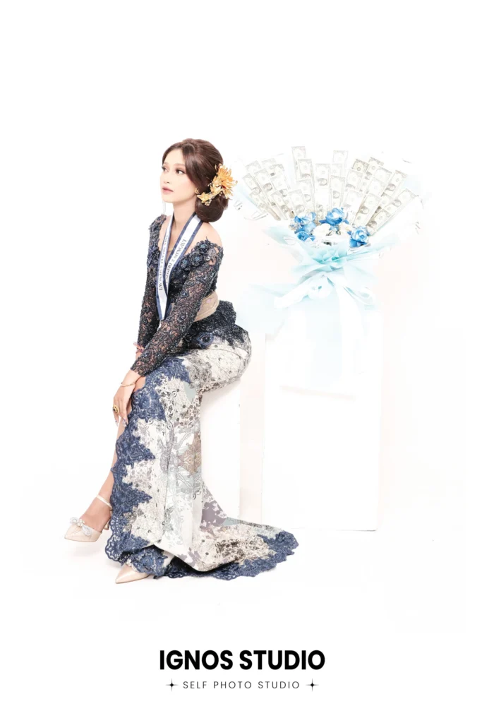 Wanita berpose anggun mengenakan kebaya modern biru motif bunga di Ignos Studio