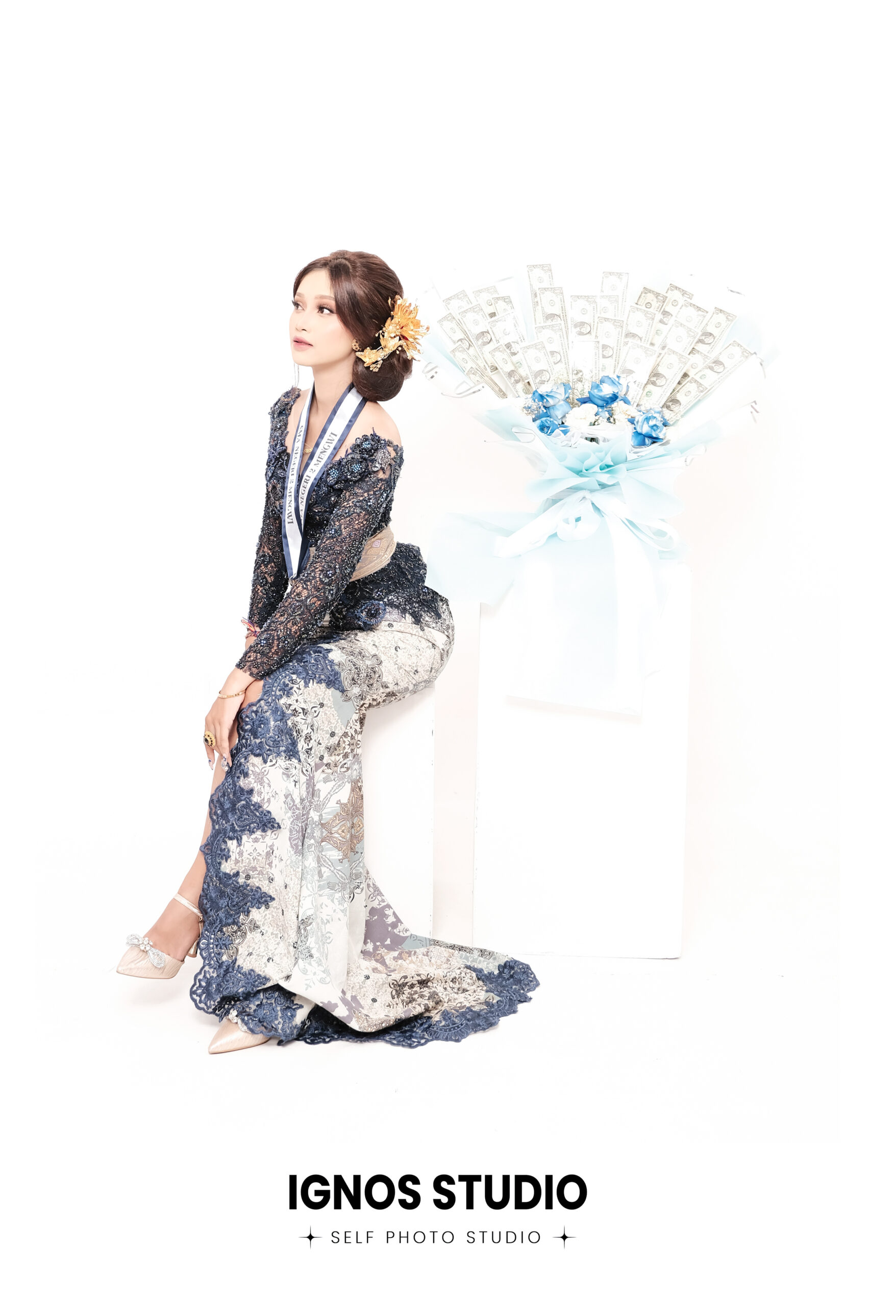 Wanita berpose anggun mengenakan kebaya modern biru motif bunga di Ignos Studio