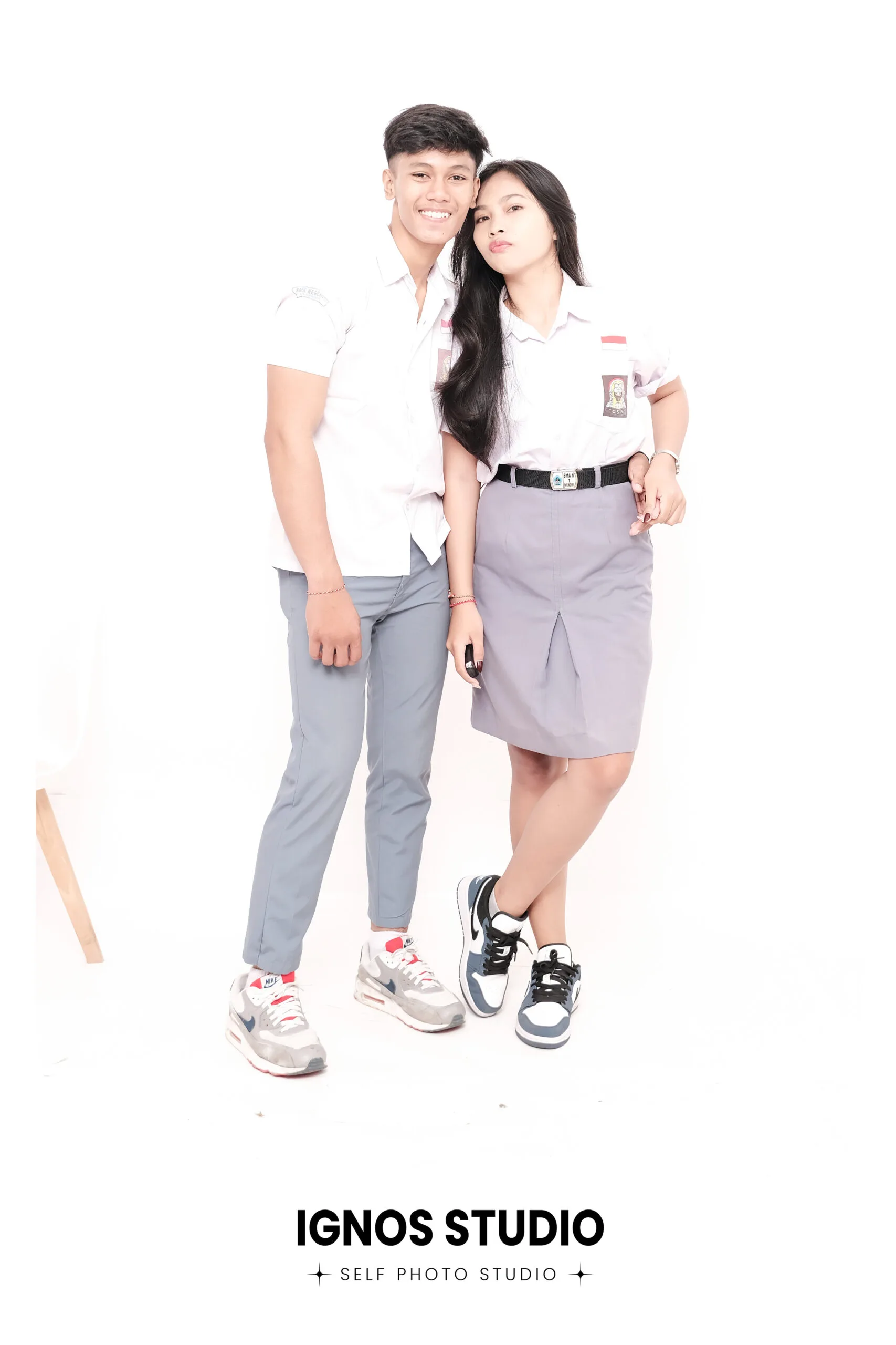 Pasangan siswa mengenakan seragam SMA berpose di Ignos Studio untuk foto yearbook atau dokumentasi sekolah